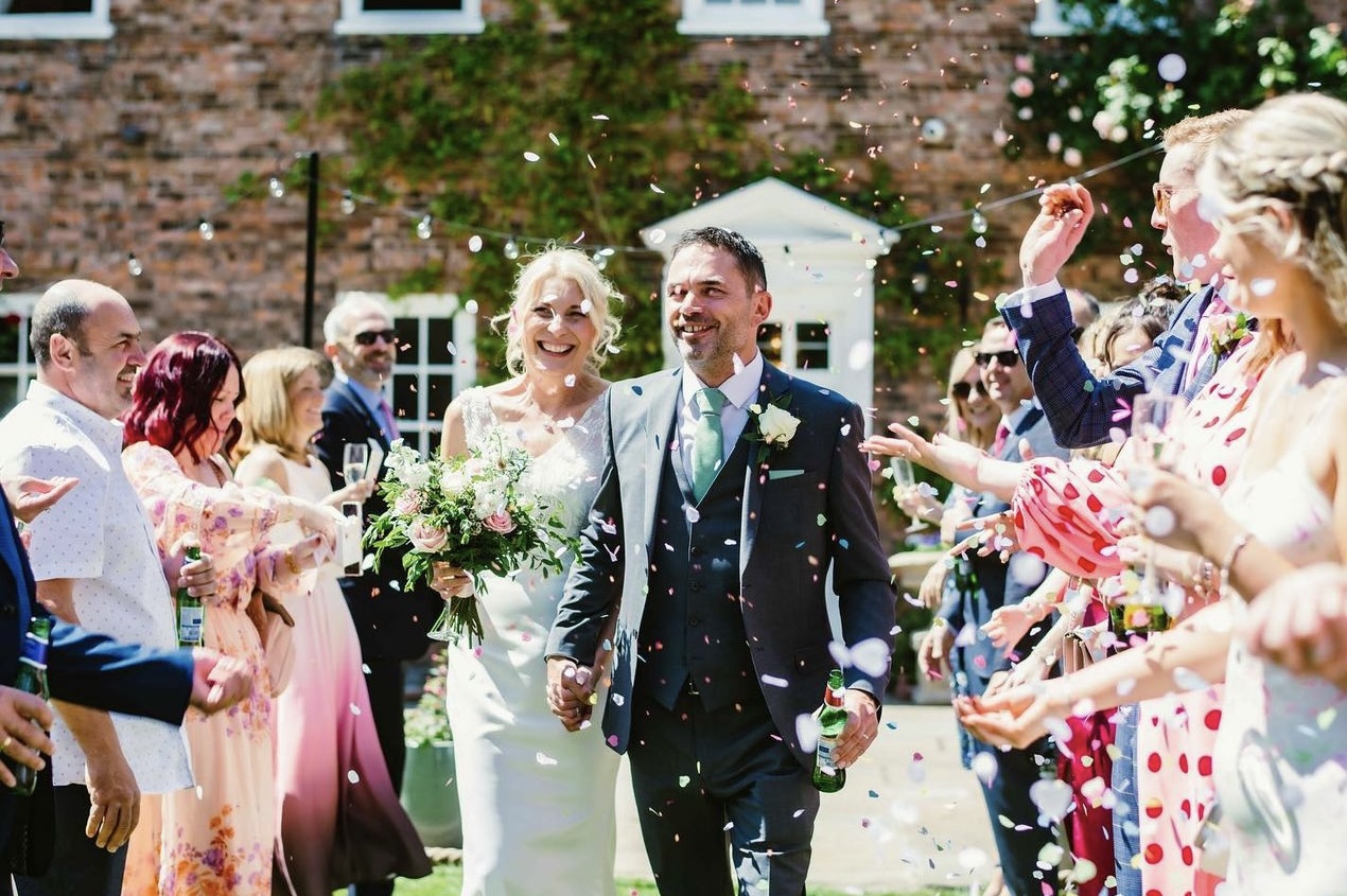 happy couple showered with confetti after wedding ceremony