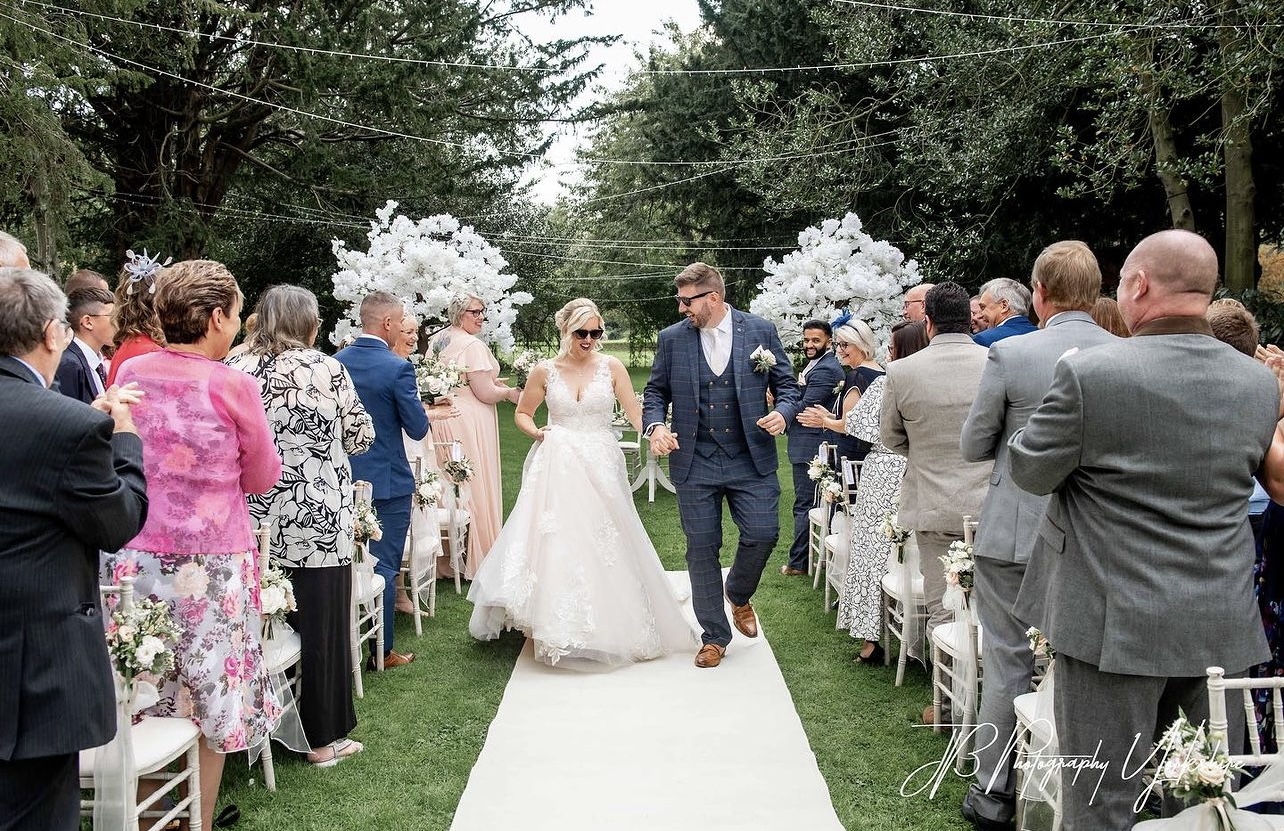 happy couple walking down aisle outdoors