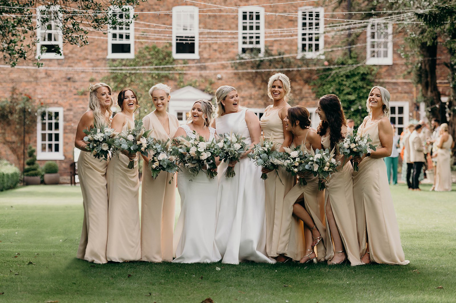 Bridal party on lawned gardens at Bardney Hall country house wedding venue